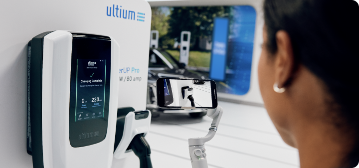 Woman at a charging station about to use the Ultium EV charging unit